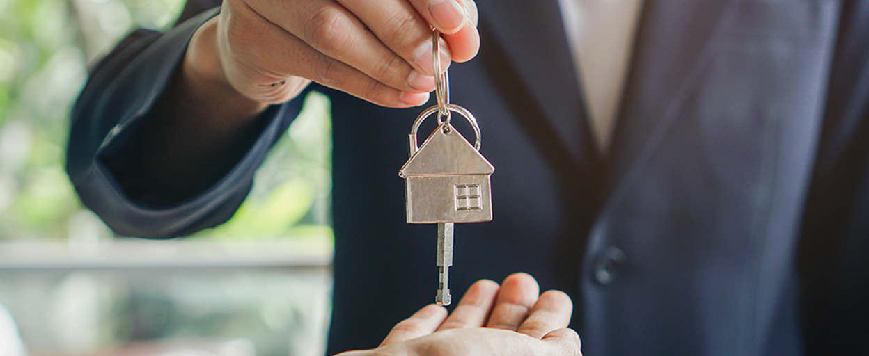 Man handing keys to outstretched hand